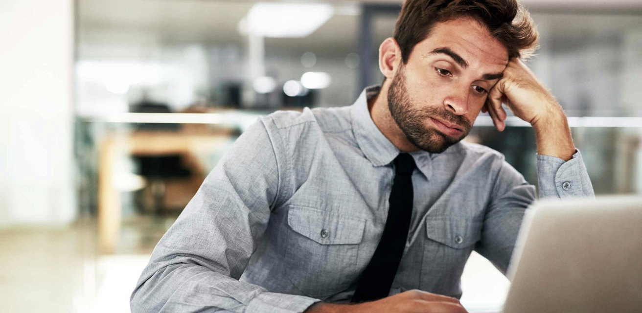 man looking at laptop with a sigh