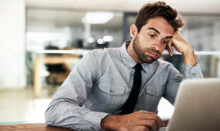 man looking at laptop with a sigh